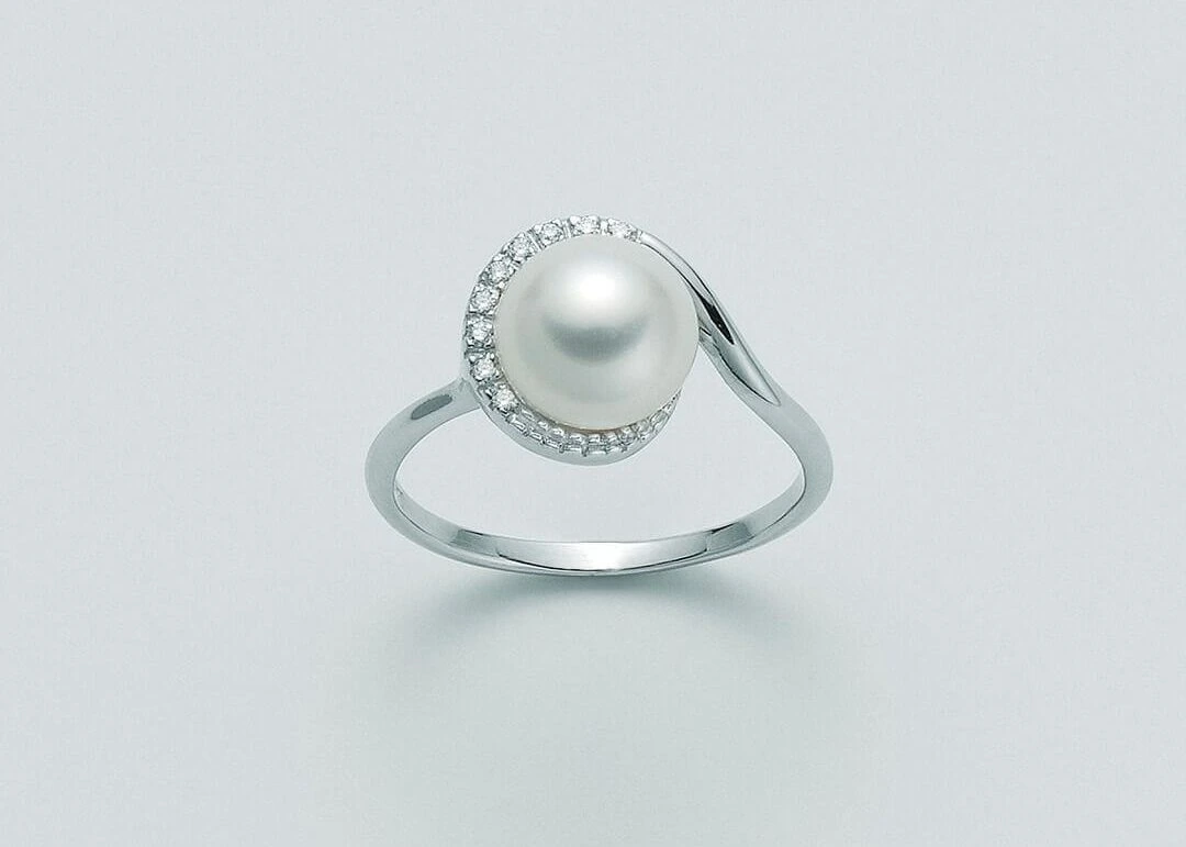 Anello con perla centrale e piccoli elementi chiari